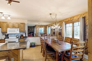 A wooden interior with a kitchen, dining area, and large windows. - Ground-floor home with high-speed WiFi, pool & hot tub - next to lift (Steamboat Springs)