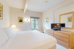 Ein Schlafzimmer mit Bett, Schminktisch, Fernseher und Fenster.