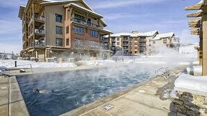 Een zwembadgedeelte met een jacuzzi, omringd door meerlaagsgebouwen met balkons.