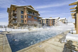 Ein Poolbereich mit Whirlpool, umgeben von mehrstöckigen Gebäuden mit Balkonen.
