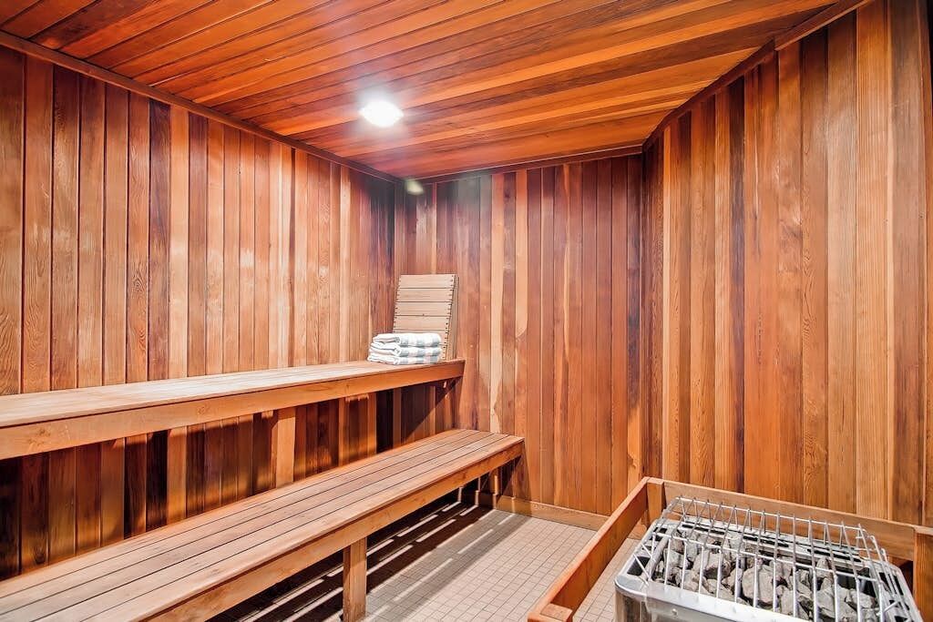 Una sauna con bancos de madera y un banco con toallas.
