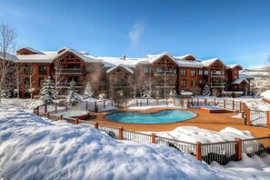 En stor stuga med en pool, omgiven av snö.