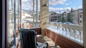 Ein Balkon mit Blick auf eine verschneite Landschaft und Häuser.