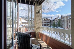 Ein Balkon mit Blick auf eine verschneite Landschaft und Häuser.