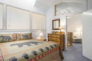 A bedroom with a bed, a dresser, a mirror, and a window with blinds. - Loft condo with Flattop Mountain views, shared hot tubs, gas fireplace, & gym (Steamboat Springs)