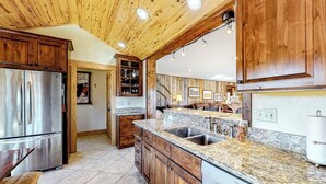 A kitchen with wooden cabinets, granite countertops, stainless steel appliances, and a built-in dishwasher. - Dog-friendly riverfront retreat with hot tub, stunning views & screened porch (South Fork)