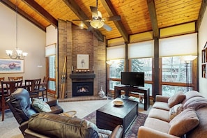 A living room with a fireplace, leather sofas, a television, and a ceiling fan. - Large suite in Steamboat Springs with pool & hot tubs (Steamboat Springs)