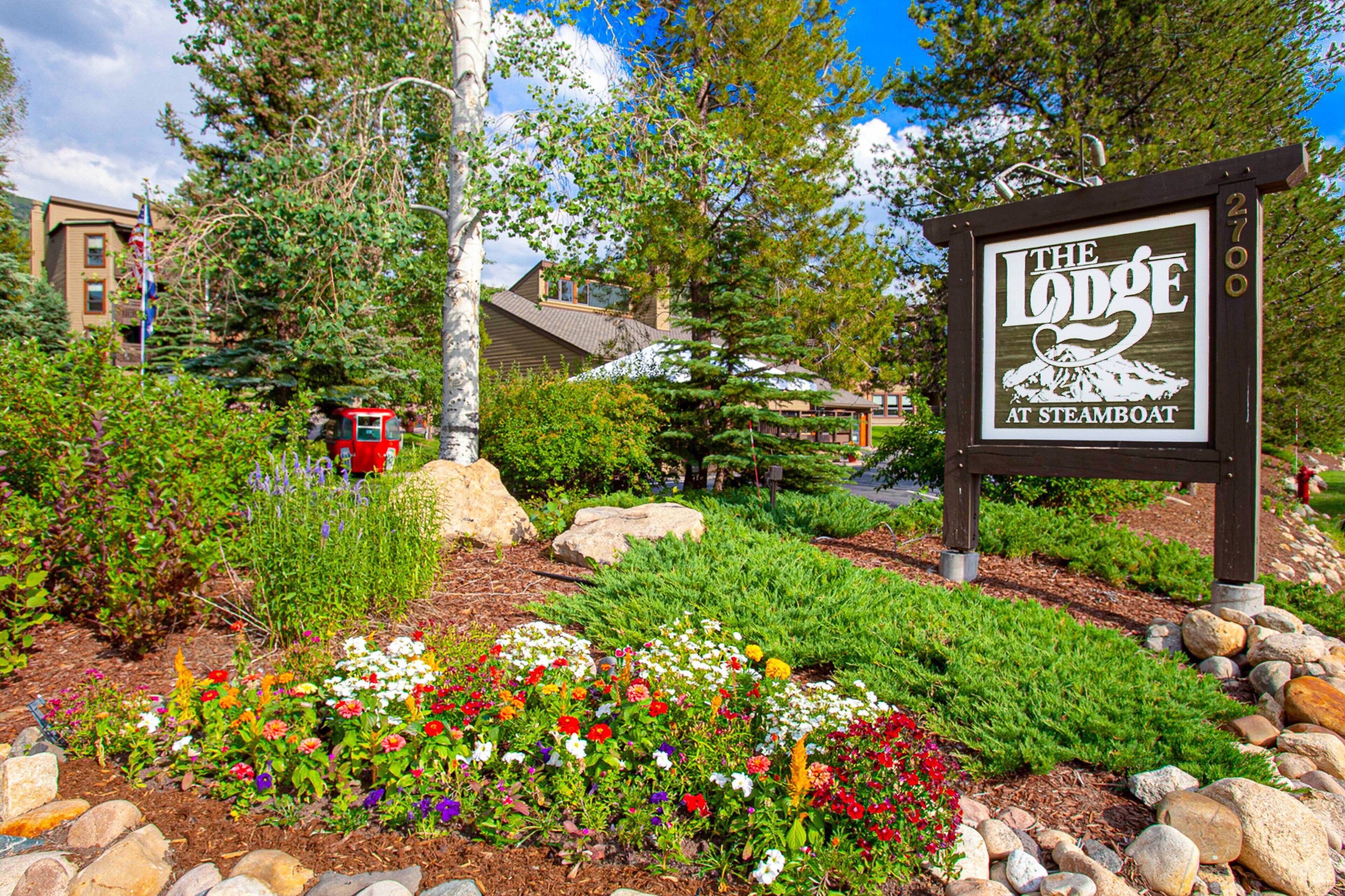 A sign for 'The Lodge at Steamboat' with a garden in the foreground.