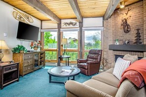Ein Wohnzimmer mit Kamin, Ledersessel und Wand-Fernseher.