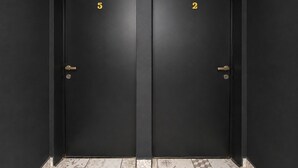 Two black doors with numbers 5 and 2, and a patterned floor.