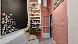 A narrow hallway with a bookshelf, a radiator, and a water heater.