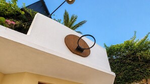 A building with a white exterior, a wooden door, and a satellite dish.