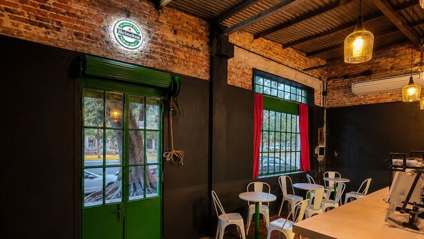 A restaurant interior with brick walls, green doors, and tiled flooring.
