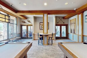 A pool table, a bar area, and a dining table in a room with wooden beams and large windows. - Keystone Condo w/Mountain Views, Shared Pool/Hot Tub - Near Ski Lift/Restaurants (Keystone)
