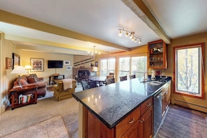 A spacious living area with a large island, a fireplace, and a television. - Inviting Snowmass condo short walk from activities with balcony (Snowmass Village)