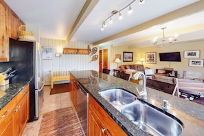 A kitchen with wooden cabinets, a granite countertop, and a stainless steel sink. - Inviting Snowmass condo short walk from activities with balcony (Snowmass Village)