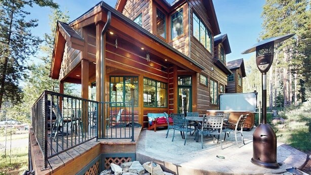A log cabin with a covered porch, outdoor seating, and a solar-powered lantern. - Luxury mountain estate w/ private hot tub, home theater, two W/Ds, & spa (Keystone)