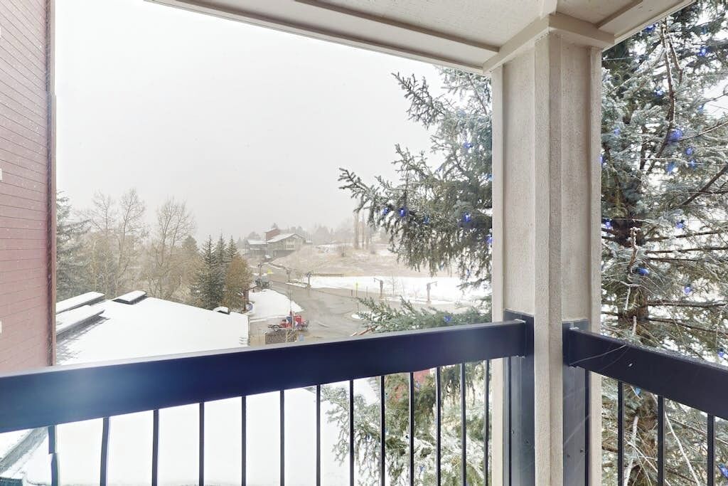 Ein Balkon mit Blick auf eine verschneite Straße und einen Weihnachtsbaum.