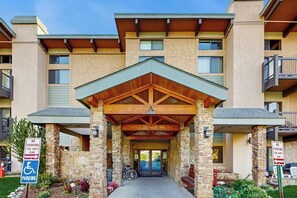 A building entrance with a stone facade, a covered porch, and a sign indicating a no parking tow away zone. - Ski-In/Out Top-Floor Condo w/Free WiFi, Fireplace, and Shared W/D, Hot Tub, Pool (Steamboat Springs)