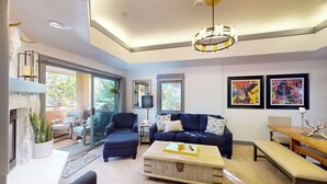 A modern living room with a sofa, coffee table, and artwork on the wall. - Canyon Creek B304 - Top-Floor Mountain Area Condo w/ Balcony, Gas Grill, Shared Heated Pool & Spa (Steamboat Springs)