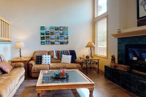 Ein Wohnzimmer mit Sofa, Couchtisch, Kamin und Wandbildern.