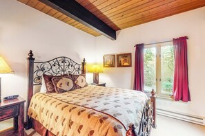 A bedroom with a bed, two bedside lamps, a window with curtains, and a wall with two framed pictures. - Ski-In/Ski-Out Condo w/ Gas Fireplace, Balcony & Shared Hot Tub (Steamboat Springs)