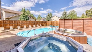 Ein Garten mit Pool, Whirlpool und Liegestühlen.