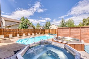 Ein Garten mit Pool, Whirlpool und Liegestühlen.