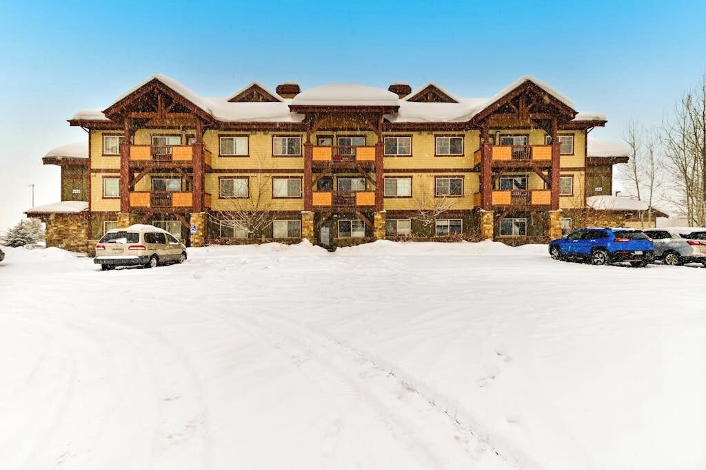Ein mehrstöckiges Gebäude mit einer symmetrischen Fassade, großen Fenstern und einem mit Schnee bedeckten Dach.