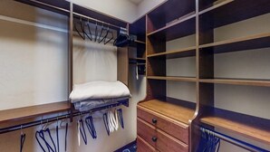 Ein begehbarer Kleiderschrank mit Holzböden, Ablageflächen und einer Sitzbank.