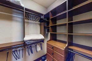 Ein begehbarer Kleiderschrank mit Holzböden, Ablageflächen und einer Sitzbank.