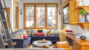 Ein modernes Wohnzimmer mit einer Eckcouch, einem runden Couchtisch und integrierten Holzböden.