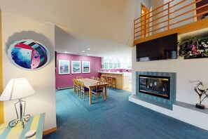 Ein modernes Interieur mit Essbereich, Küche und Kamin.