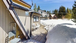 A wooden building with a deck, outdoor chairs, and snow. - Cozy mountain-view house with full kitchen, dog-friendly & convenient location (Winter Park)