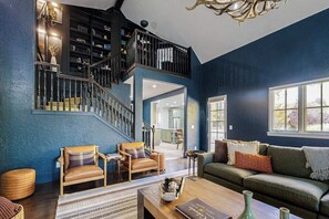 A spacious living area with a staircase, a green sofa, and a coffee table. - Spacious home w/ private hot tub, modern kitchen, grill & great location (Edwards)