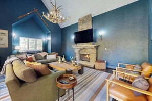 A living room with a fireplace, a television, and a large window. - Spacious home w/ private hot tub, modern kitchen, grill & great location (Edwards)