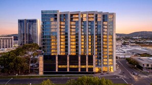A multi-story hotel with a modern design, featuring a prominent entrance and a view of the surrounding urban area.