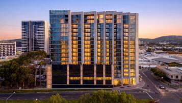 Een hotel met meerdere verdiepingen, met een modern design, een opvallende ingang en uitzicht op de omliggende stad.