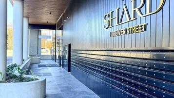 Een modern gevelontwerp met een opvallend bord waarop 'The SHARD' en 'Breezer Street' staat.