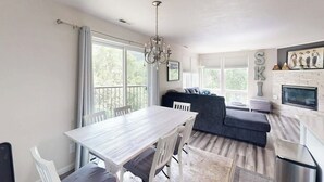 Una cocina moderna con una mesa de comedor, sillas, un sofá y una araña.