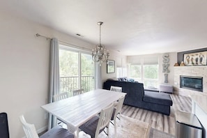 Eine moderne Küche mit Esstisch, Stühlen, einer Couch und einer Kristallleuchter.