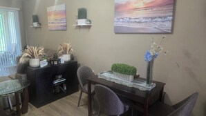 A dining area with a table, chairs, a decorative plant, and wall art. - Bright & Airy 3-bdrm near attractions w/ gorgeous community pool in Kissimmee (Kissimmee)