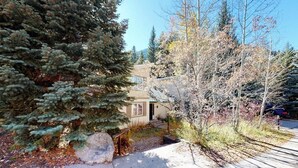 A residential property with a house, a driveway, and surrounding trees. - Creekside Condo w/ Deck: Short Drive to Skiing, Vail Village & Golf (Vail)