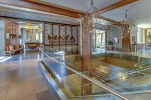 Ein modernes Interieur mit Glastrennwand, Holzbalken und Wandverkleidung mit Muster.
