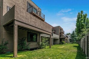 Ein modernes, zweistöckiges Gebäude mit flachem Dach, großen Fenstern und einer überdachten Terrasse.