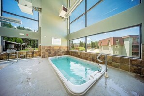 A spa area with a hot tub, large windows, and a view of the outside. - Mtn-view condo with in/out pools, hot tub, fireplace, great views, rec center (Winter Park)
