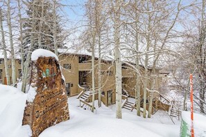 Ein schneebedecktes Gebäude mit einem Holzschild, auf dem 'Clubhouse Gordinimminums' steht.