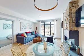 Ein modernes Wohnzimmer mit Sofa, Couchtisch und Kamin.