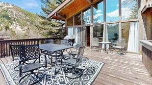 A wooden deck with outdoor furniture, a large window, and a mountain view. - Spacious Mountain Lodge-Style Home with Free WiFi - Nearby Ski Access (Aspen)