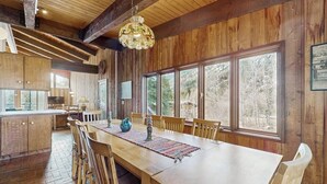 A wooden interior with a dining table, chairs, and a chandelier. - Spacious Mountain Lodge-Style Home with Free WiFi - Nearby Ski Access (Aspen)